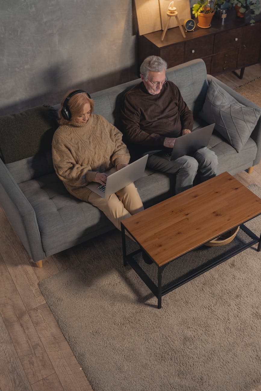 man and woman sitting on gray couch
